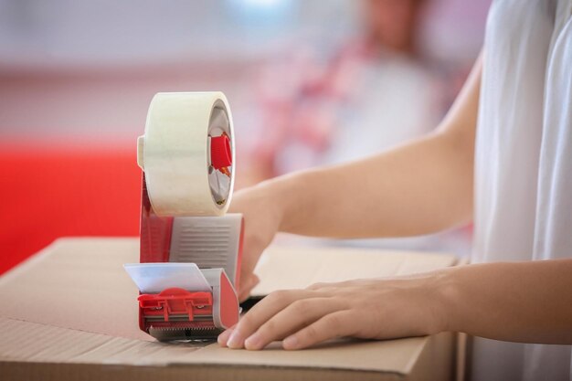 Photo young woman packing box at home closeup house move concept