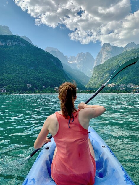 Young woman paddling on kayak at molveno lake italy