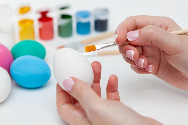 Young woman painting Easter eggs