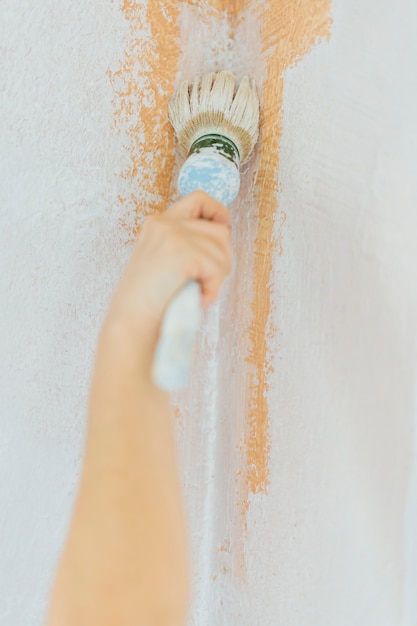 Young woman painting the walls of her home.