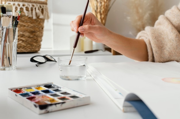 Photo young woman painting with watercolors on paper