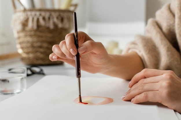 Young woman painting with watercolors on paper