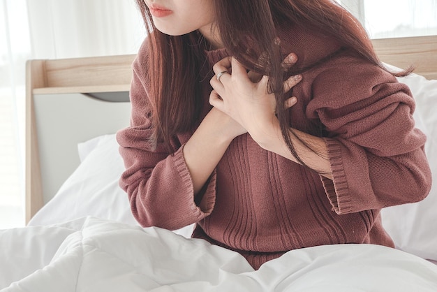 Young woman in pajamas having heart attack