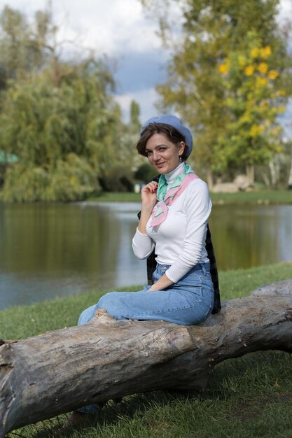 Young woman in the park speaks by mobile phone Cute girl portrait in french style