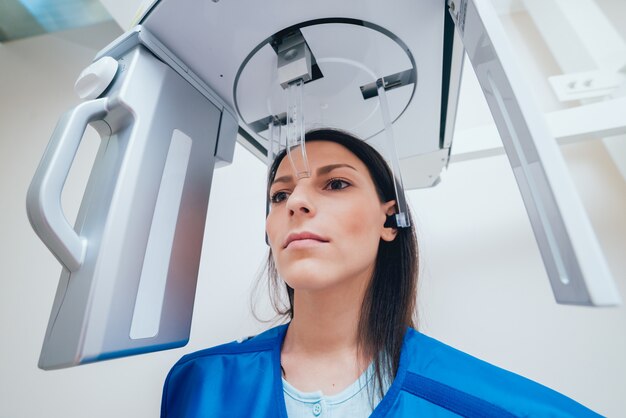 Young woman patient standing in x-ray machine.