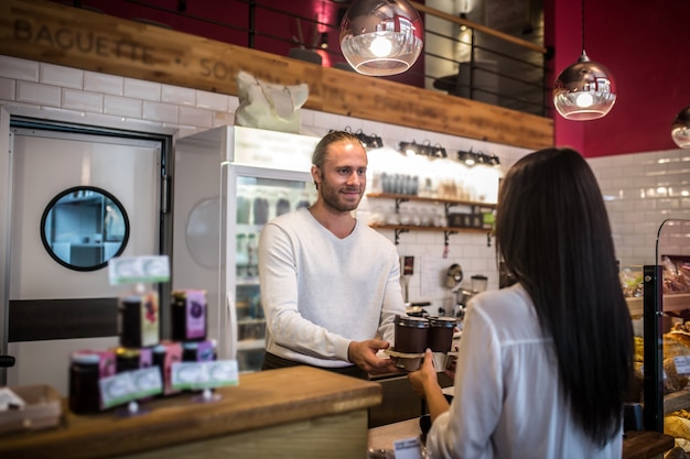 Photo young woman paying in a coffee shop