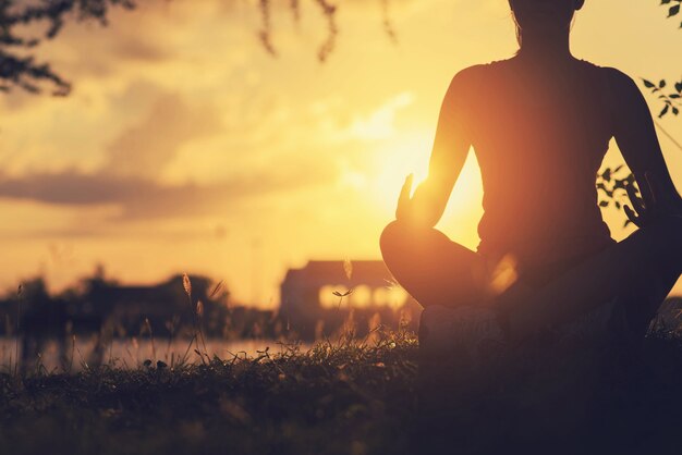 Young woman peacefully meditating in a open field.