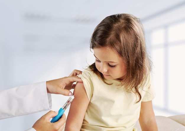 Young woman pediatrician performs a vaccination of