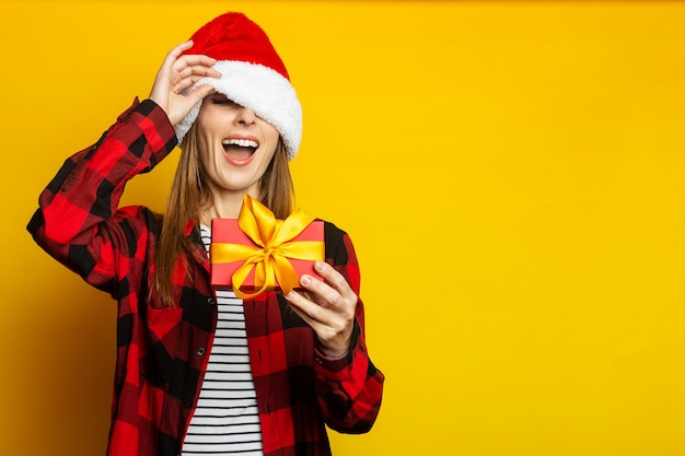 Young woman peeks out from under a santa hat