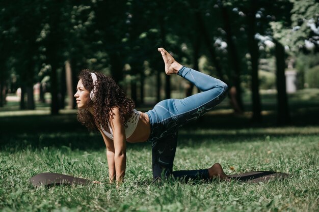 Young woman performing a fitness exercise exercise in the park o