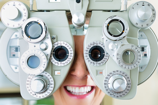 Photo young woman at phoropter for eye test