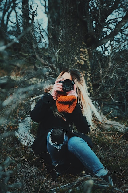 Foto giovane donna che fotografa con la macchina fotografica all'aperto