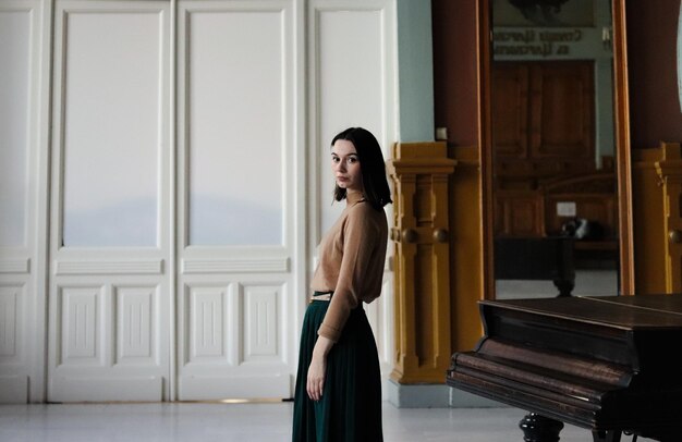 Foto giovane donna e pianoforte in un interno art deco