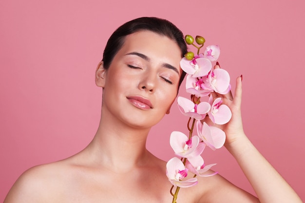 A young woman and a pink orchid