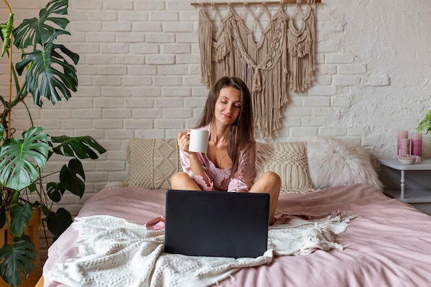 Young woman in pink pajamas  lying on the bed at home