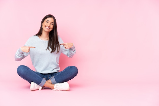 Young woman on pink proud and self-satisfied