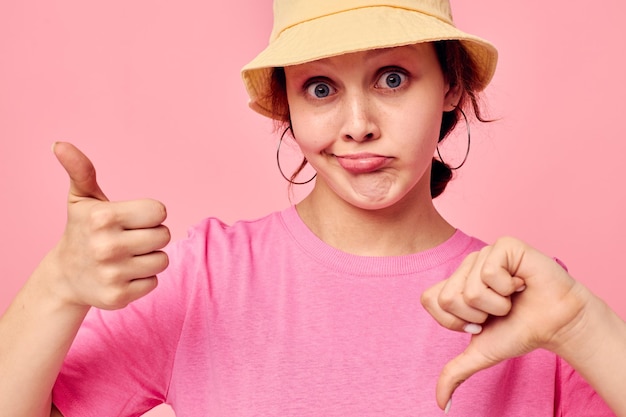 Foto giovane donna in una maglietta rosa e cappello moda giovanile colore rosa sfondo