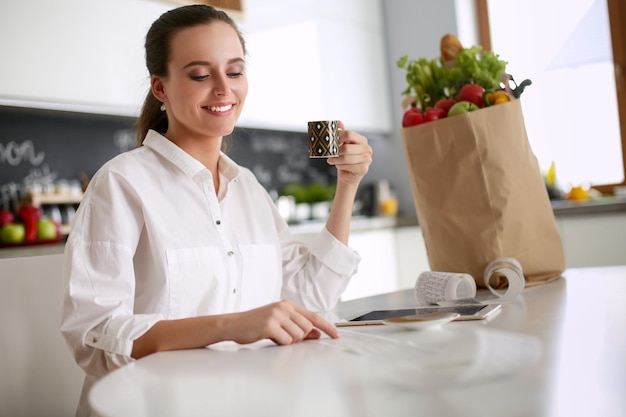 Young woman planning expenses and paying bills on her kitchen