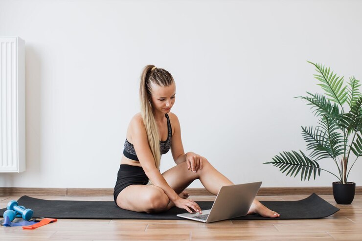 Photo young woman planning her workout routine on a laptop