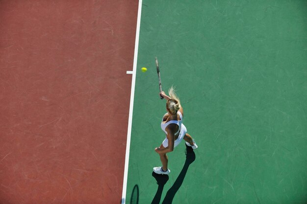 Foto giovane donna che gioca a tennis all'aperto