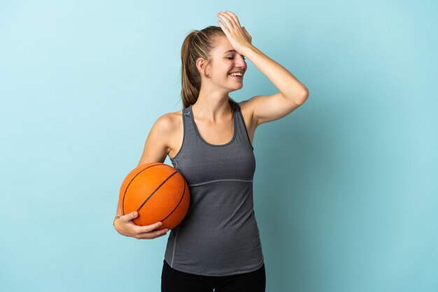 Young woman playing basketball isolated on blue has realized something and intending the solution