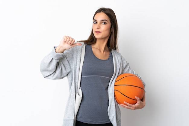 Young woman playing basketball isolated on white background proud and self-satisfied