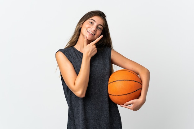 Молодая женщина играет в баскетбол изолированы