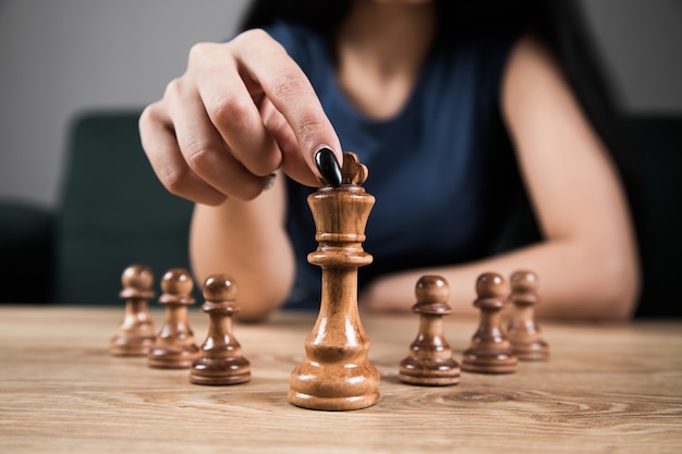 Young woman playing chess alone