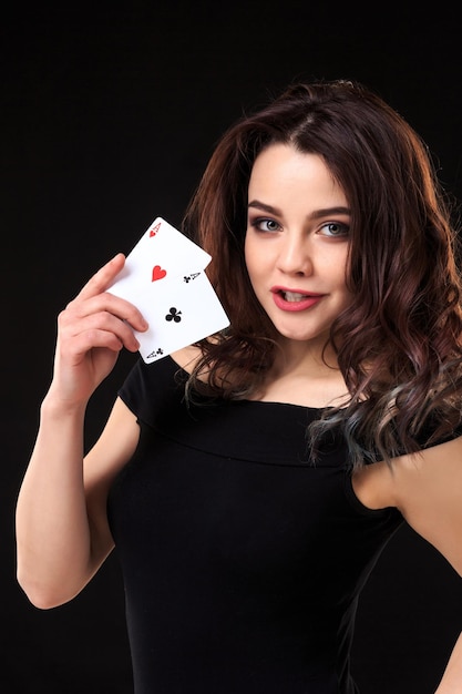 Young woman playing in the gambling on black background