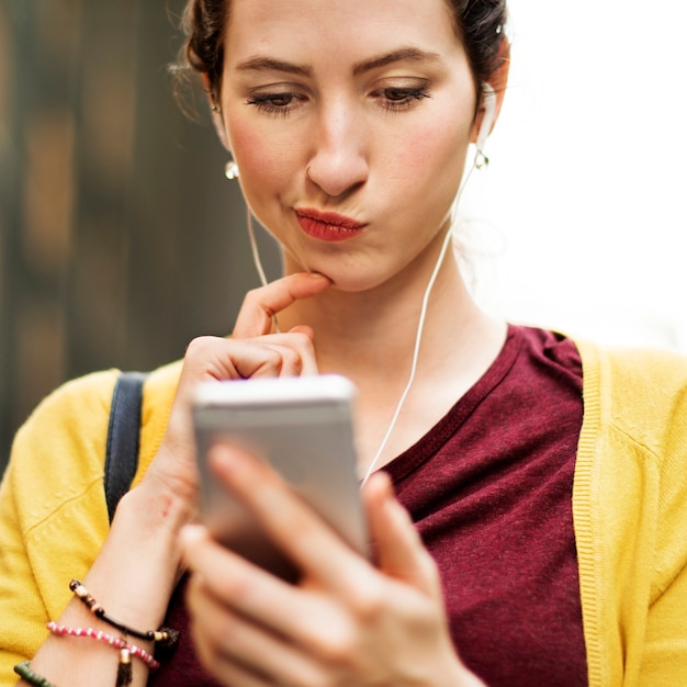 彼女の電話で遊んでいる若い女性