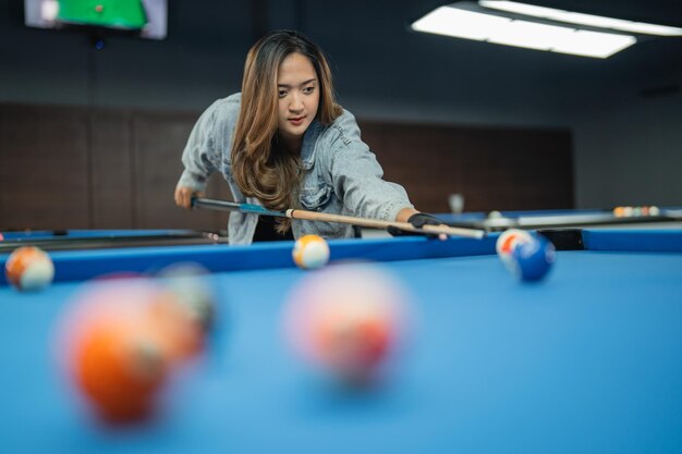 Young woman playing pool