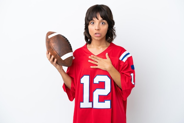 Young woman playing rugby isolated on white background surprised and shocked while looking right