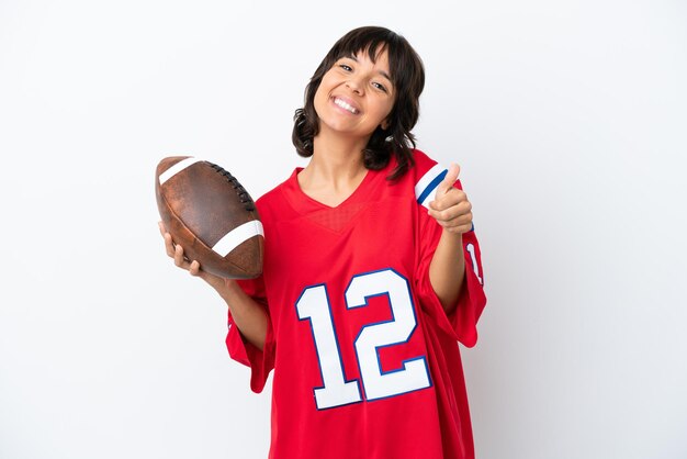 Young woman playing rugby isolated on white background with\
thumbs up because something good has happened