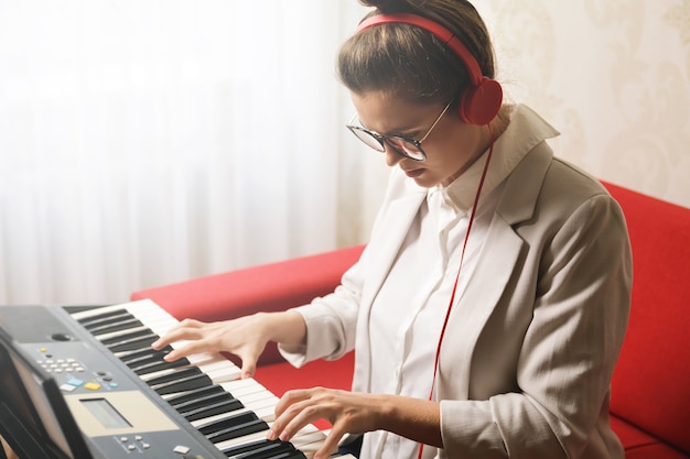 Young  woman playing synthesizer at home