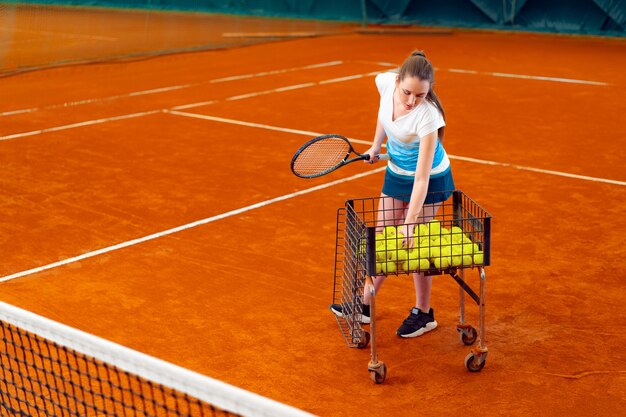 Young woman playing tennis at indoor tennis court