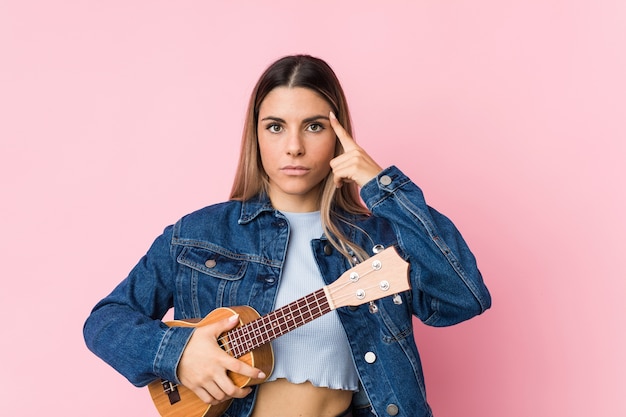 Young woman playing ukulele