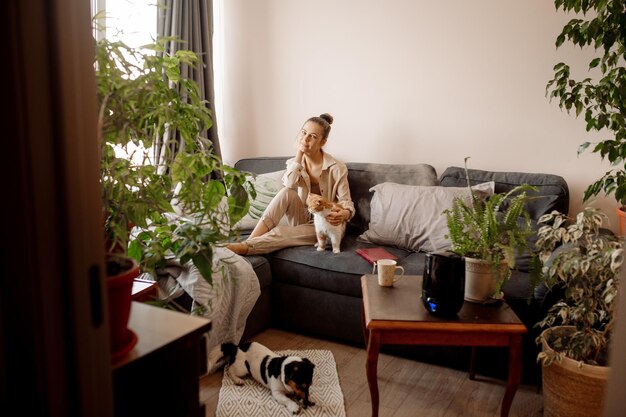 Young woman playing with cat at home