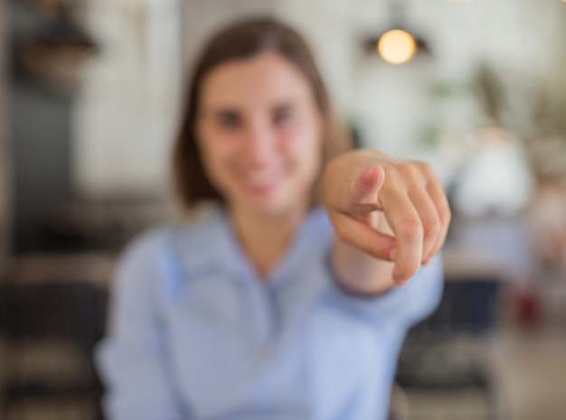 young woman pointing against company background