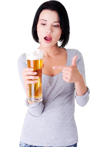 Photo young woman pointing at beer glass against white background