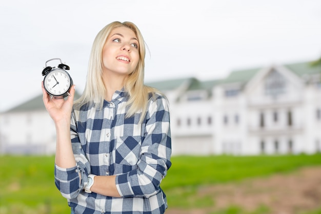 Young woman pointing on clock