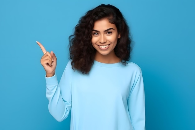 Young woman pointing finger to side latin girl isolated on blue