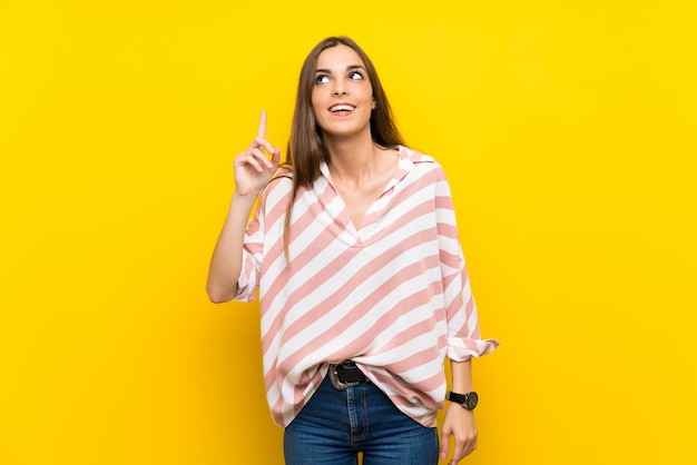 Young woman pointing up and surprised