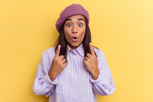 Young woman pointing upside with opened mouth.