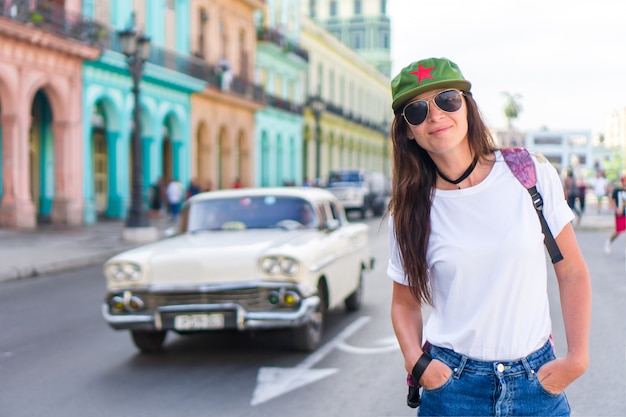 Young woman in popular area in old Havana, Cuba. Beautiful girl traveler, colorful houses in the city