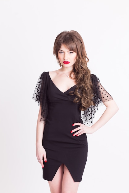 A young woman  portrait in a black dress with red lipstick