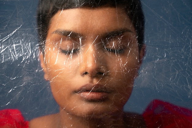 Young woman portrait behind plastic wrap