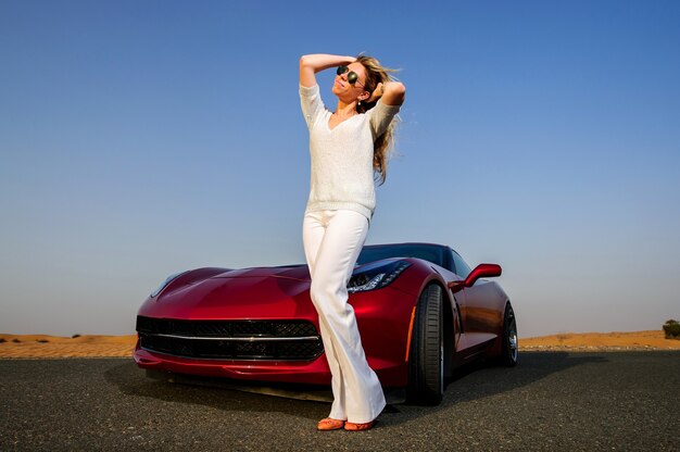 A fashion woman in stylish glasses, a striped t-shirt and jeans sits on the  trunk of a car and looks at the beautiful nature of autumn 22071188 Stock  Photo at Vecteezy