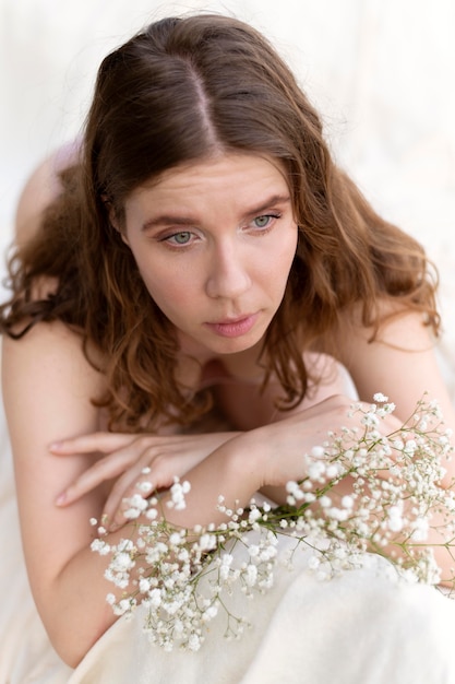 Young woman posing confidently in lingerie with flowers