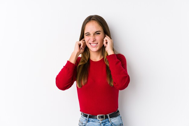 Young woman posing isolated  covering ears with hands