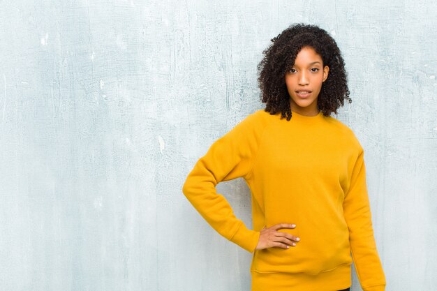 Photo young woman posing in orange sweater with expressive face